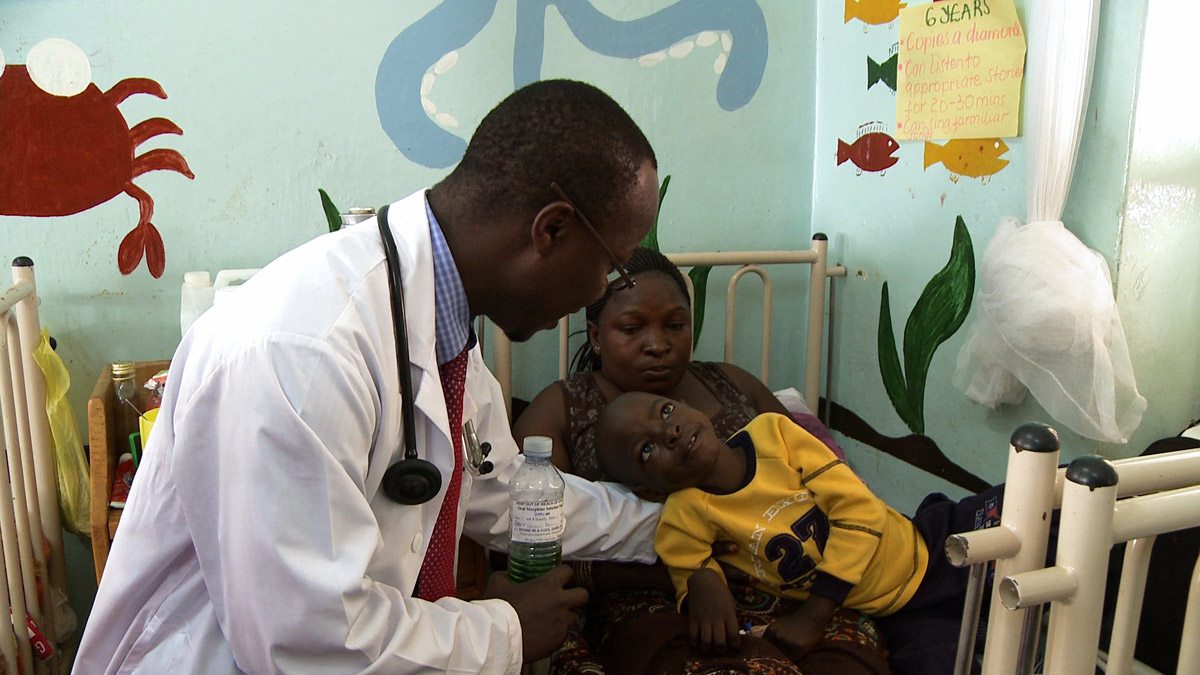 Child-Cancer-Patient-Wasswa-with-Dr-Henry-Ddungu-holding-Lidquid-Morphine_Kampala-Uganda